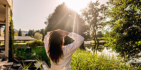 Dunkelhaarige Frau genießt den Sonnenschein im Garten